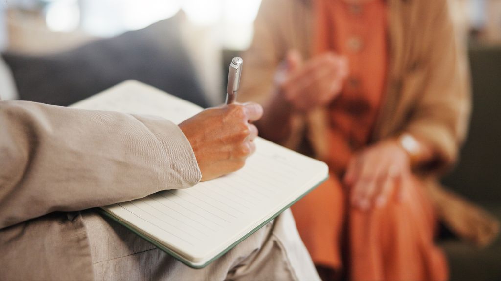 A female mental capacity assessor taking notes during a mental capacity assessment